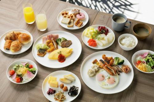 a table with plates of breakfast foods and drinks at Courtyard by Marriott Tokyo Ginza Hotel in Tokyo
