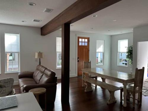 a living room with a table and a couch at Gator Grove - Colonial House - Brand New Build! in Gainesville