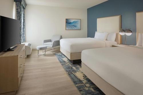 a hotel room with two beds and a television at Courtyard by Marriott Sandestin at Grand Boulevard in Destin