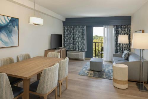 a living room with a dining room table and a couch at Courtyard by Marriott Sandestin at Grand Boulevard in Destin