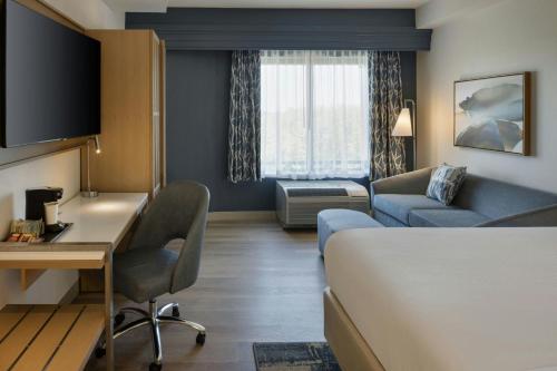 a hotel room with a bed and a desk and a couch at Courtyard by Marriott Sandestin at Grand Boulevard in Destin