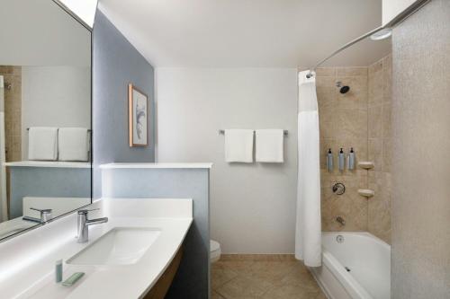 a white bathroom with a sink and a shower at Courtyard by Marriott Sandestin at Grand Boulevard in Destin