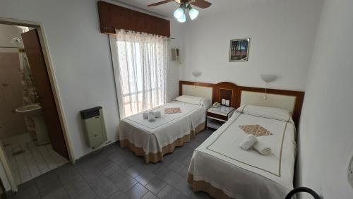 a hotel room with two beds and a window at Hotel San Martin in Villa María
