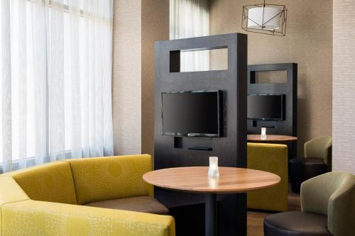 a hotel room with a table and chairs and a tv at Courtyard by Marriott Richmond Berkeley in Richmond