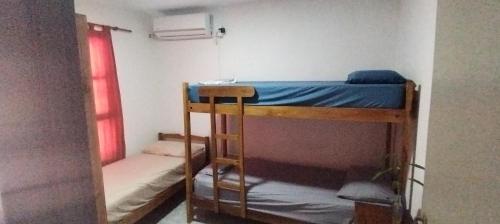 a room with two bunk beds and a window at La casa de Tilili in Puerto Iguazú