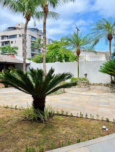 a palm tree in the middle of a courtyard at Santa Rita Pousada in Guarujá