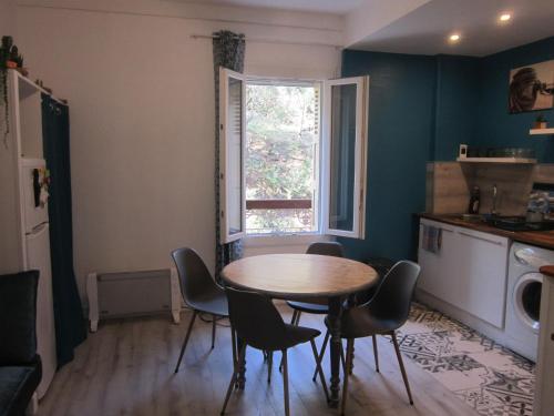 une cuisine avec une table et des chaises et une fenêtre dans l'établissement Appart F2 à 150 M de la plage avec parking privé, à Cerbère