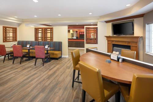 Una sala de espera con mesa y sillas y una chimenea. en TownePlace Suites by Marriott Bentonville Rogers, en Bentonville
