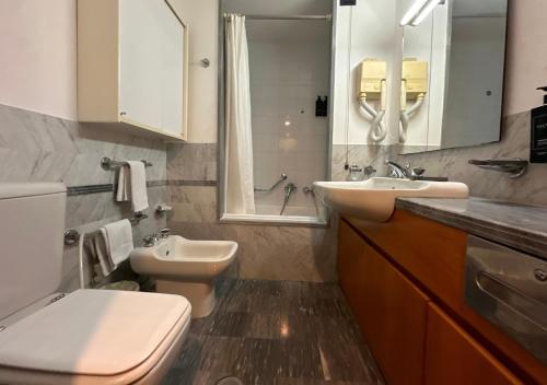 a bathroom with a toilet and a sink and a mirror at Hotel Europa in Taranto