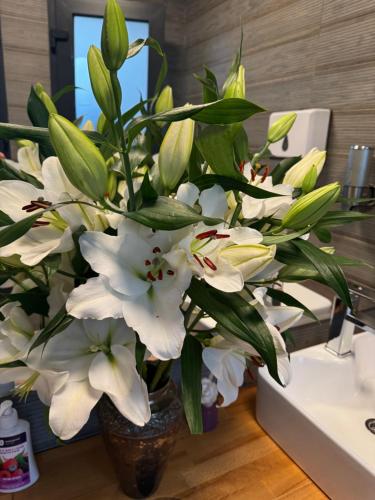 a vase filled with white flowers on a table at Готельно-ресторанний комплекс Фамілія in Bushtyno