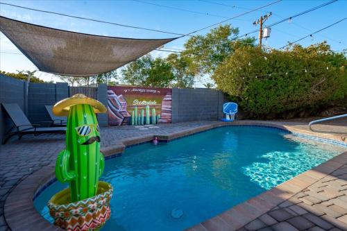 a swimming pool with a cactus in the middle at Basketball Court & Heated Pool, 1 Mi To Old Town! in Scottsdale