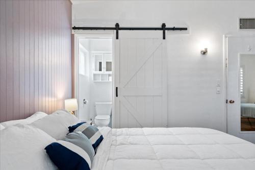 a white bedroom with a large bed and a door at Basketball Court & Heated Pool, 1 Mi To Old Town! in Scottsdale