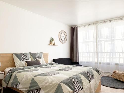 パリにあるNice apt nearby arc triomphe champe elyseeのベッドルーム1室(ベッド1台、壁掛け時計付)