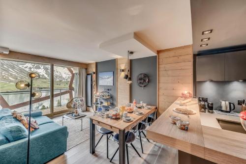un salon avec une table et un canapé bleu dans l'établissement Résidence Phoenix - 3 Pièces pour 4 Personnes MAE-0401, à Tignes