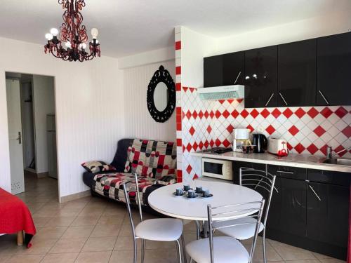 une cuisine et un salon avec une table et un canapé dans l'établissement Résidence Héliopolis Bâtiment E - HELIOPOLIS Bâtiment E - 2 personnes rez-de -chaussée MAE-4544, au Cap d'Agde