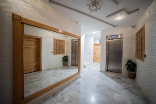 a hallway with a door and a tile floor at Appart familial climatisé, spacieux et raffiné avec vue sur jardin - Proche de l'aéroport, Marjane et de la forêt" in Fès