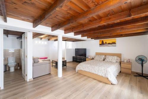 una camera da letto con un letto e un divano in una stanza di Apartment Geranio - Rural Guest Apartment a Tías