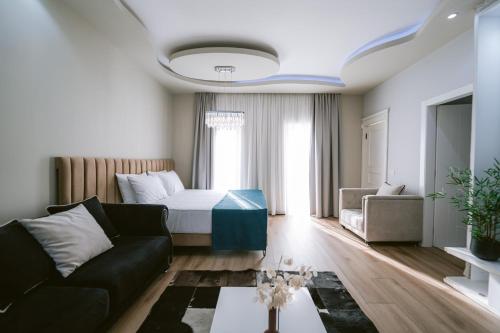 a living room with a bed and a couch at TRIBUTE Hotel in Shkodër