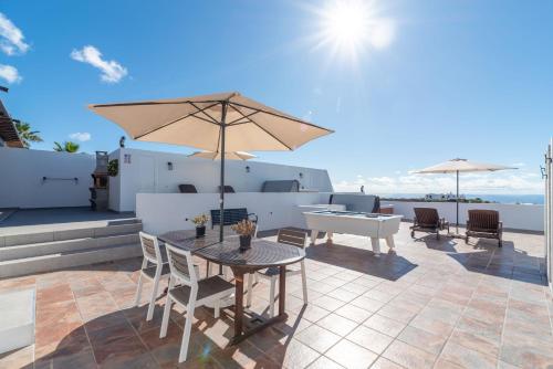 a patio with a table and an umbrella at Apartment Orquidia - Rural Guest Apartment in Tías