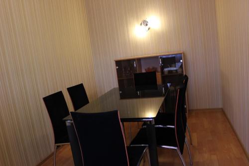 a dining room with a table and black chairs at Ust-Kamenogorsk Hotel in Ustʼ-Kamenogorsk
