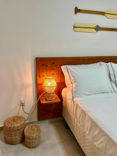 a bedroom with a bed and a lamp on a night stand at Yahweh Hotel in São Miguel do Gostoso