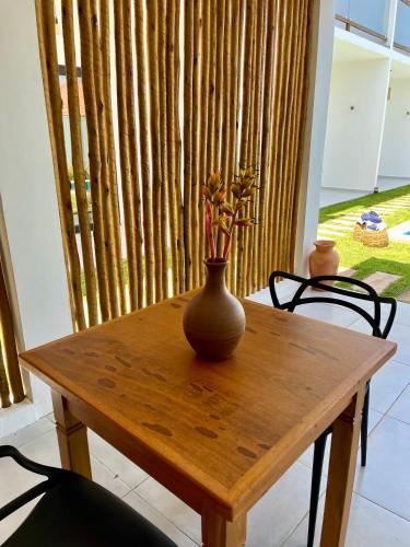 a wooden table with a vase on top of it at Yahweh Hotel in São Miguel do Gostoso