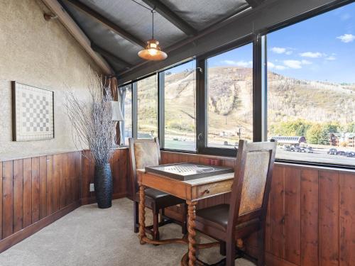 a room with a table and chairs and windows at Silver King by All Seasons Resort Lodging in Park City