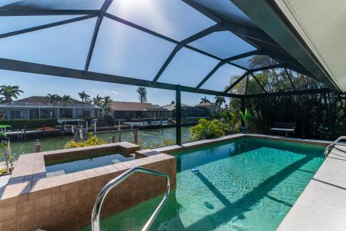 マルコ・アイランドにある"The Lighthouse" l Gorgeous Waterfront 3 Bed with Quick Access to Gulfのパラソル付きのスイミングプール