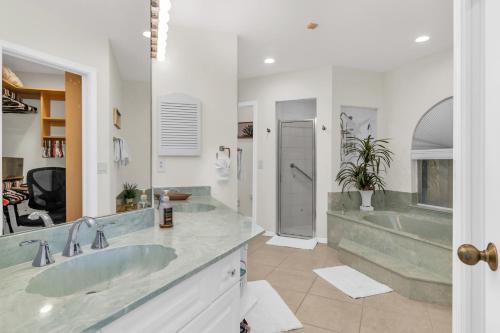a bathroom with two sinks and a tub at Gorgeous Waterfront 3 Bed with Quick Access to Gulf!! in Marco Island