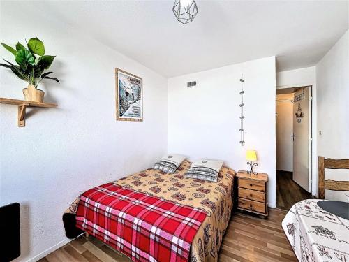 une chambre avec un lit avec une couverture à carreaux dans l'établissement Résidence Zodiaque - STUDIO CHAMBRE 2 PERSONNES MAE-1791, à Villarembert
