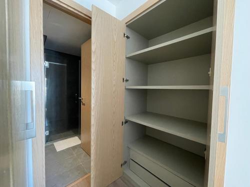 a walk in closet with wooden shelves and a door at Charmant studio avec vue sur mer in Rabat