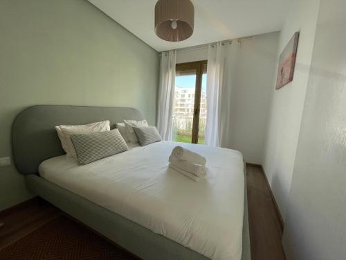 Un dormitorio con una cama con una maleta encima. en Charmant studio avec vue sur mer, en Rabat
