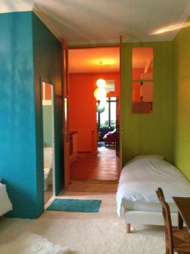 - une chambre avec des murs verts et bleus et un lit dans l'établissement L'appartement de L'Homme de Bois, à Honfleur
