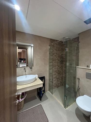 Un baño con lavabo, ducha e inodoro. en Superb apartment in the heart of city with POOL, en Marrakech