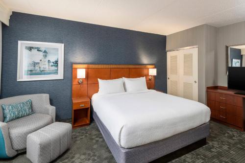 a hotel room with a bed and a chair at Courtyard Philadelphia Valley Forge Collegeville in Collegeville
