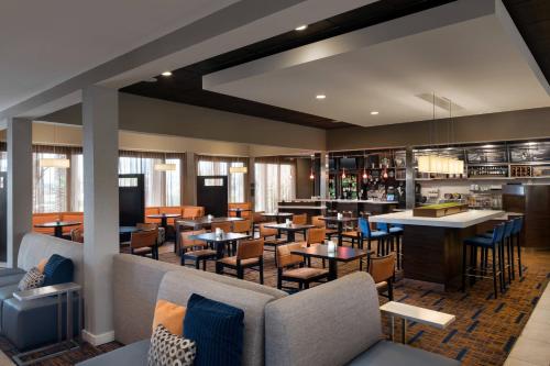 a restaurant with tables and chairs and a bar at Courtyard Tucson Airport in Tucson