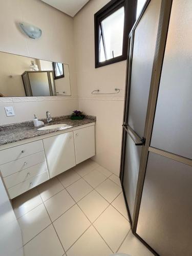 a bathroom with a sink and a mirror at Residencial Marina’s in Florianópolis