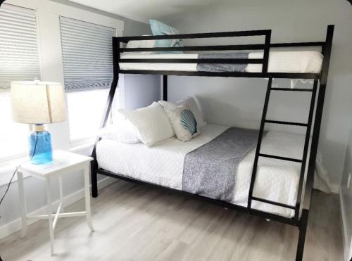 a bedroom with a bunk bed with a lamp and a table at Water View Cottage Steps to Beach in Villas