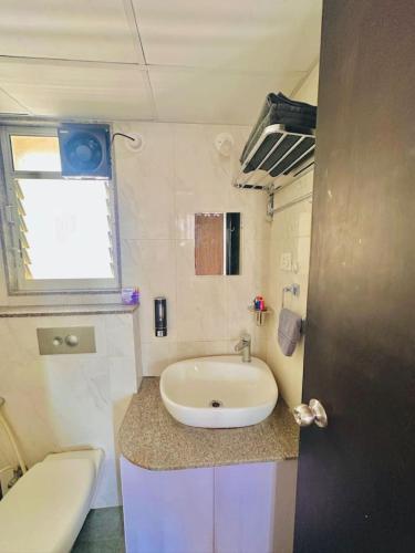 a small bathroom with a sink and a toilet at Flamingo 2BHK AC Flat Near Phoenix Mall Wakad in Méribel Village