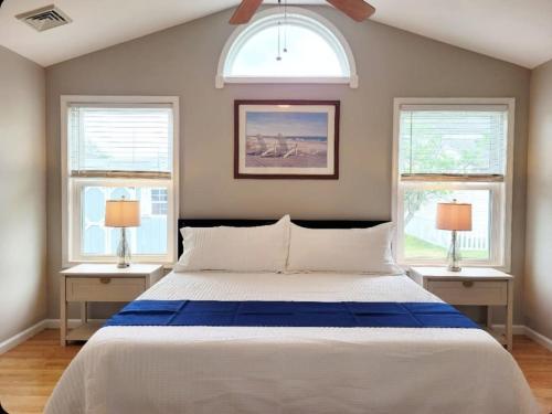 a bedroom with a large bed with two windows at Just Beachy Sleeps 10 in Wildwood Highlands Beach