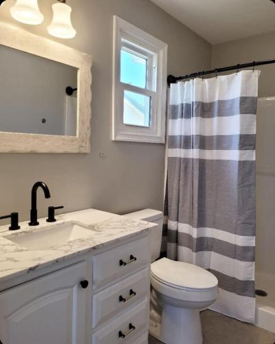 a bathroom with a sink and a toilet and a window at Just Beachy Sleeps 10 in Wildwood Highlands Beach