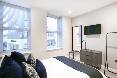 a bedroom with a bed and a flat screen tv at Churchill Square Views - Central - Modern 1 Bed Sleeps 4 in Brighton & Hove