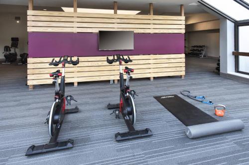 a gym with two exercise bikes and a flat screen tv at Courtyard Philadelphia Devon/Villanova in Wayne