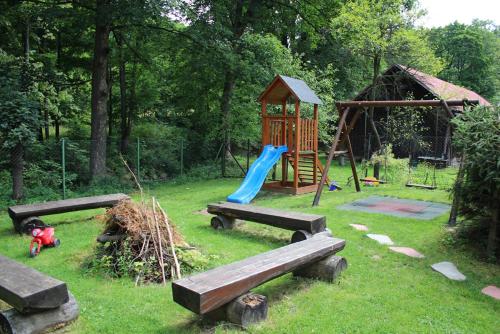 a park with a playground with a slide and a play structure at Hotel Säntis in Komorní Lhotka