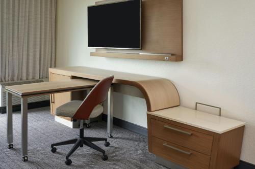 a room with a desk and a chair and a tv at Courtyard by Marriott Fort Lauderdale Weston in Weston