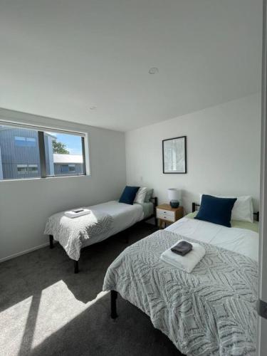 ein Schlafzimmer mit zwei Betten und einem Fenster in der Unterkunft Mohua Lane Retreat in Christchurch