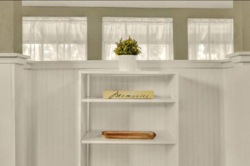 a white shelf with a wooden box on it at Charming Historic 2-story Carriage House located in Downtown Lakeland walking distance from FSC! in Lakeland