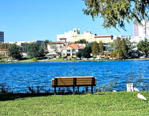 a park bench sitting next to a large body of water at Charming Historic 2-story Carriage House located in Downtown Lakeland walking distance from FSC! in Lakeland