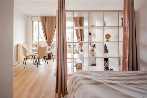 une chambre avec un lit et une salle à manger dans l'établissement Hermoso apartamento a 10 minutos De la Torre Eiffel, à Paris