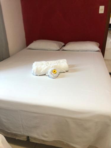 a white bed with a towel on top of it at Pousada Caminho das Cachoeiras Pirenopolis in Pirenópolis